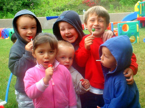 children playing outside and sucking on lollipops