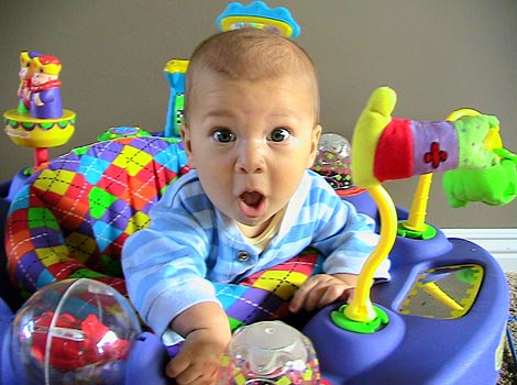 adorable baby is exersaucer with surprised face