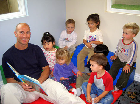 male child care provider reading at Building Blocks Home Daycare