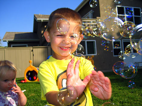 children popping bubbles outside