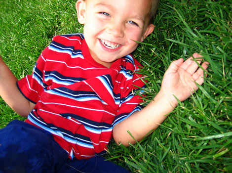 boy laughing hard in the grass