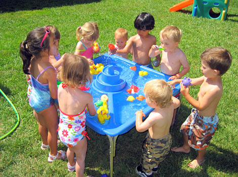kids playing in water table on hot day